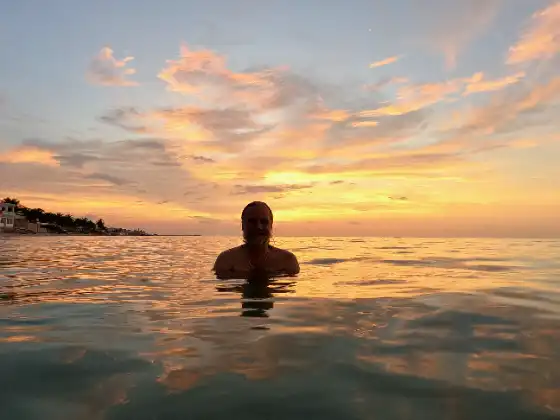 Chris floating in the ocean during sunset here in México